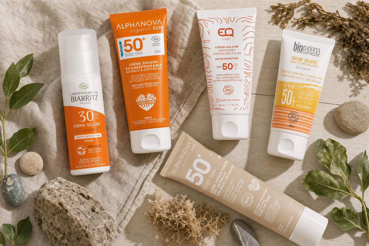 Six crèmes solaires bio visage SPF50 posées sur un fond naturel